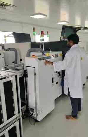 Indian factory workers assembling telecom equipment with 'Make in India'
